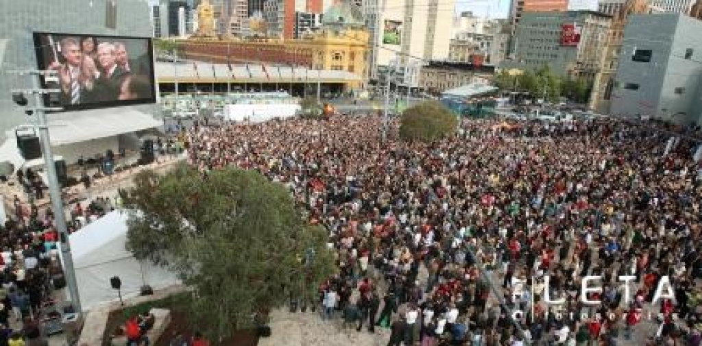 13.02.2008. Tūkstošiem austrāliešu Melburnas centrālajā laukumā uz milzīga ekrāna vēro Austrālijas premjerministra Kevina Rada vēsturisko uzrunu parlamentā, pirmo reizi valsts vēsturē atvainojoties par Austrālijas aborigēniem nodarītajām netaisnībām un ciešanām.
Autors: AFP/LETA