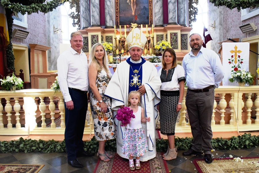 Marta Jakovela savā kristību dienā Skaistkalnes baznīcā kopā ar bīskapu Edvardu Pavlovski, vecākiem Jeļenu un Ivaru Jakoveliem (no kreisās) un krustvecākiem.
Autors: Žanna Zālīte